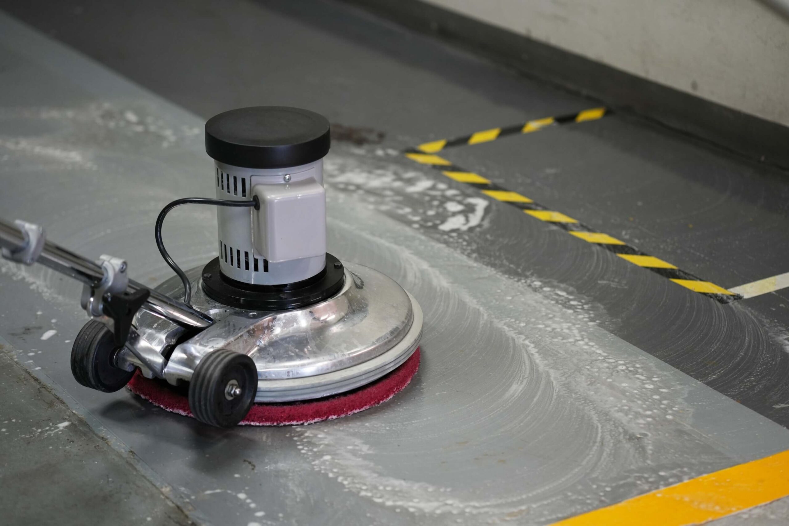 People cleaning the outdoor walkway using polishing machine